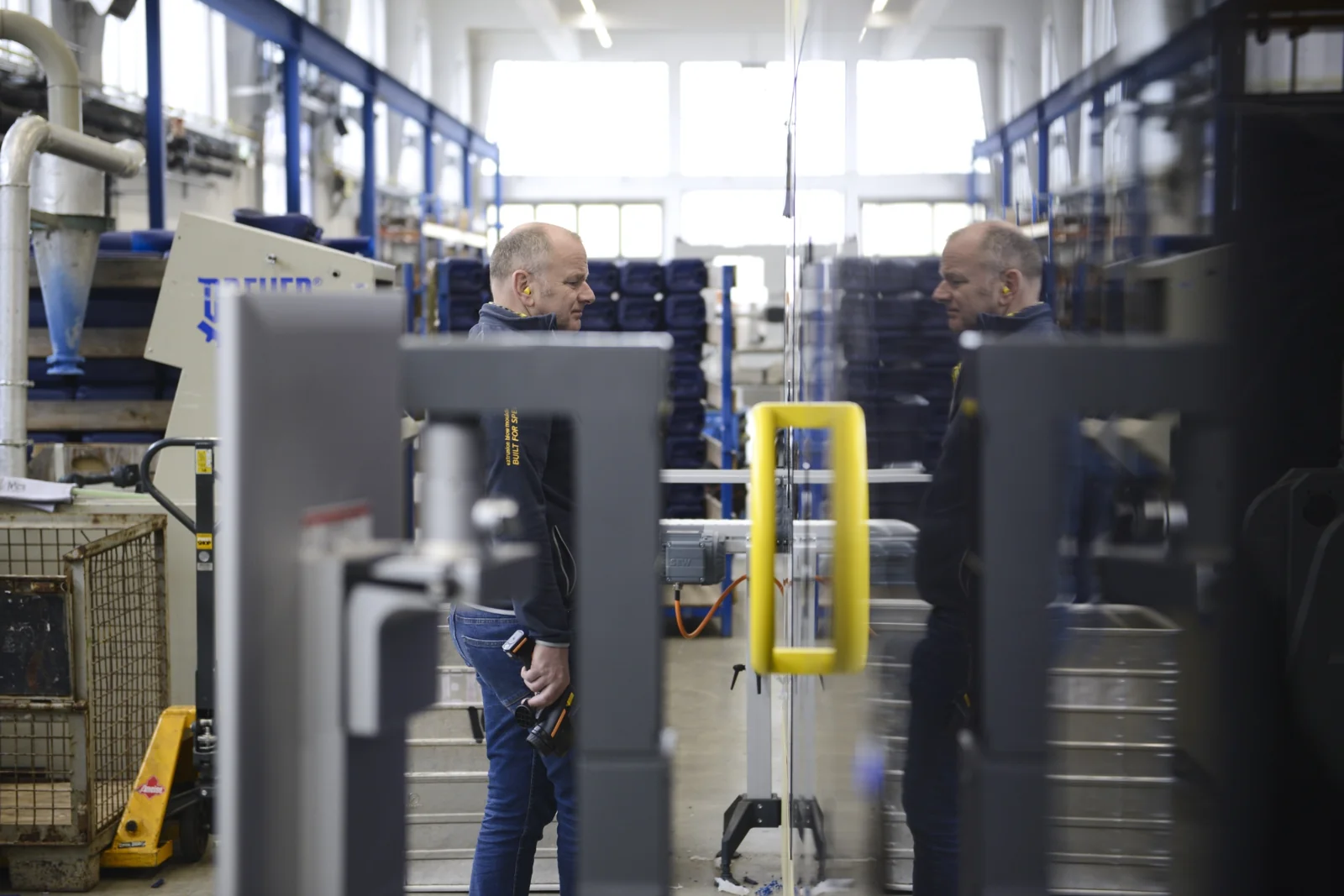 Andreas Lichtenauer at a blow moulding machine on the production floor