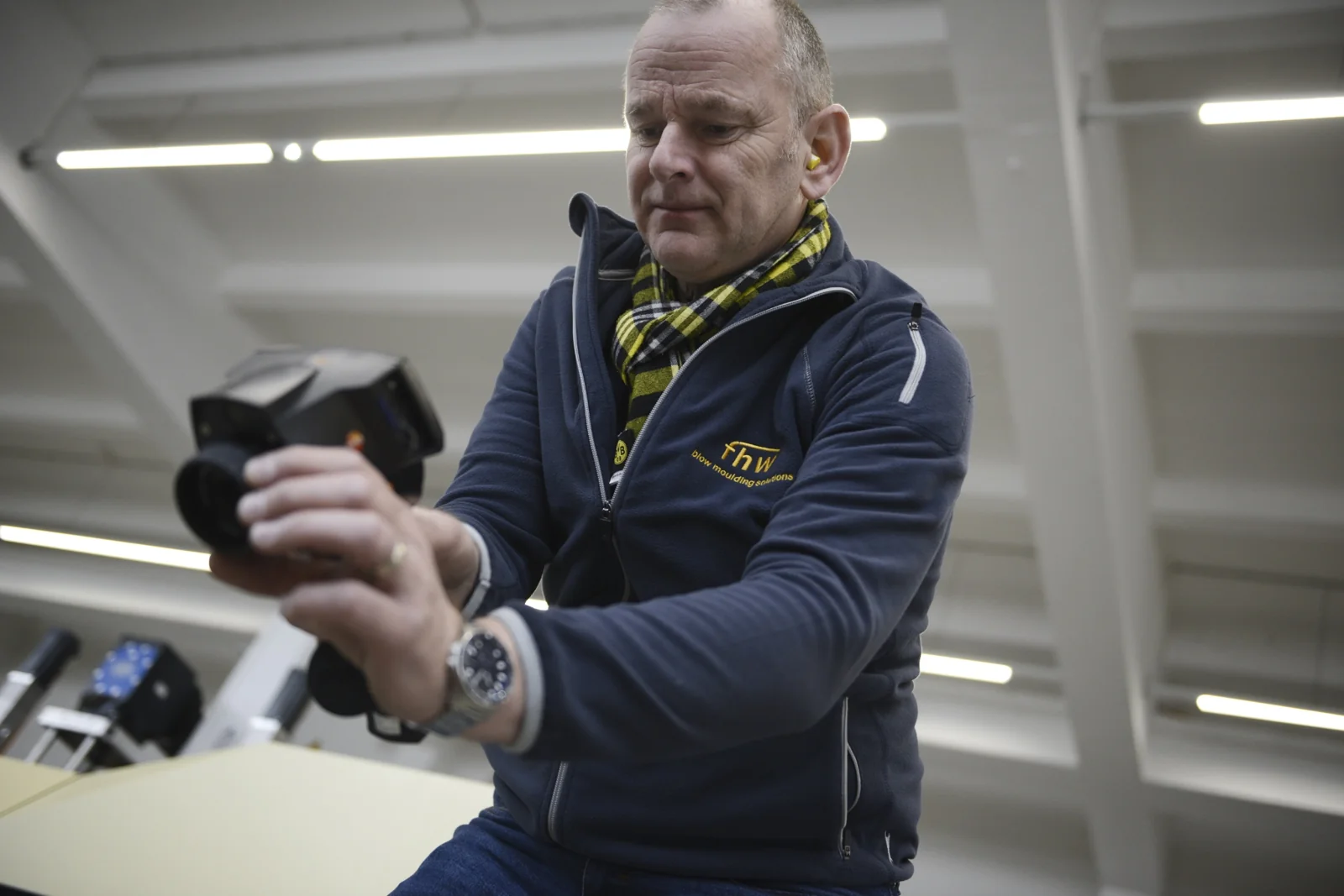 Andreas Lichtenauer examining a technical component in production